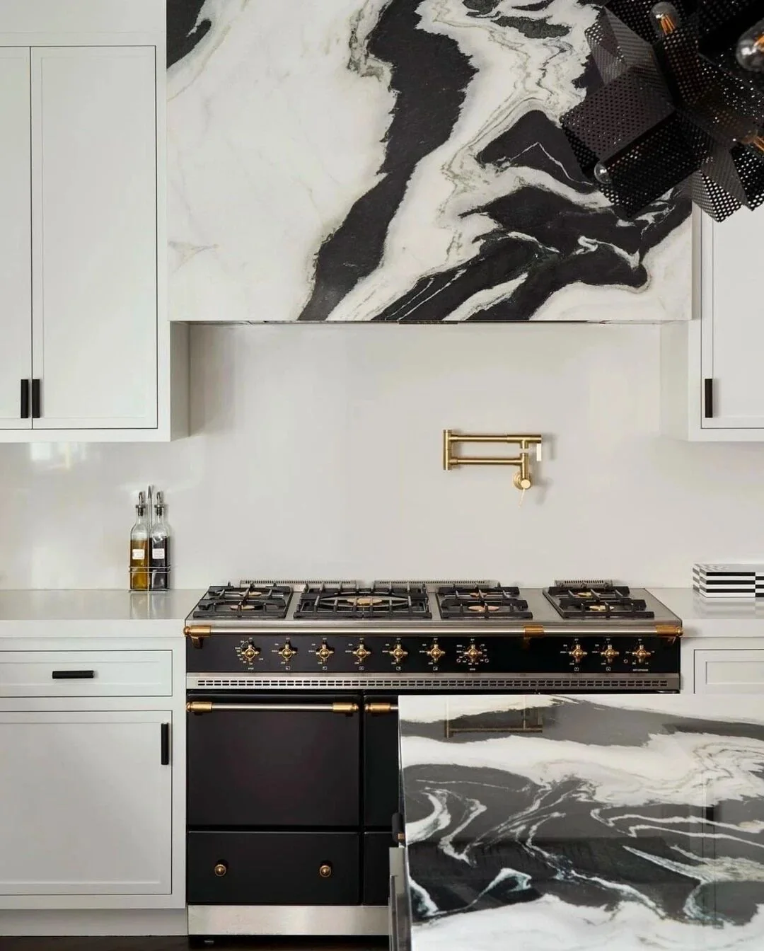 White kitchen with a framed Panda White Marble panel above the range