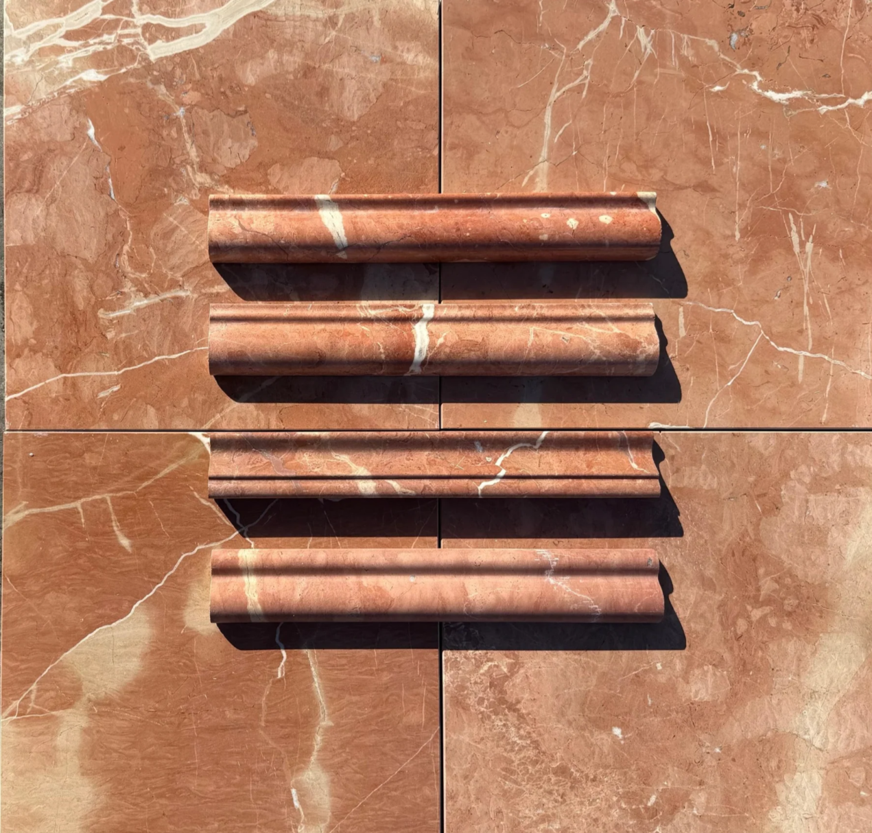 Profiled Rojo Alicante marble baseboard and architectural trim