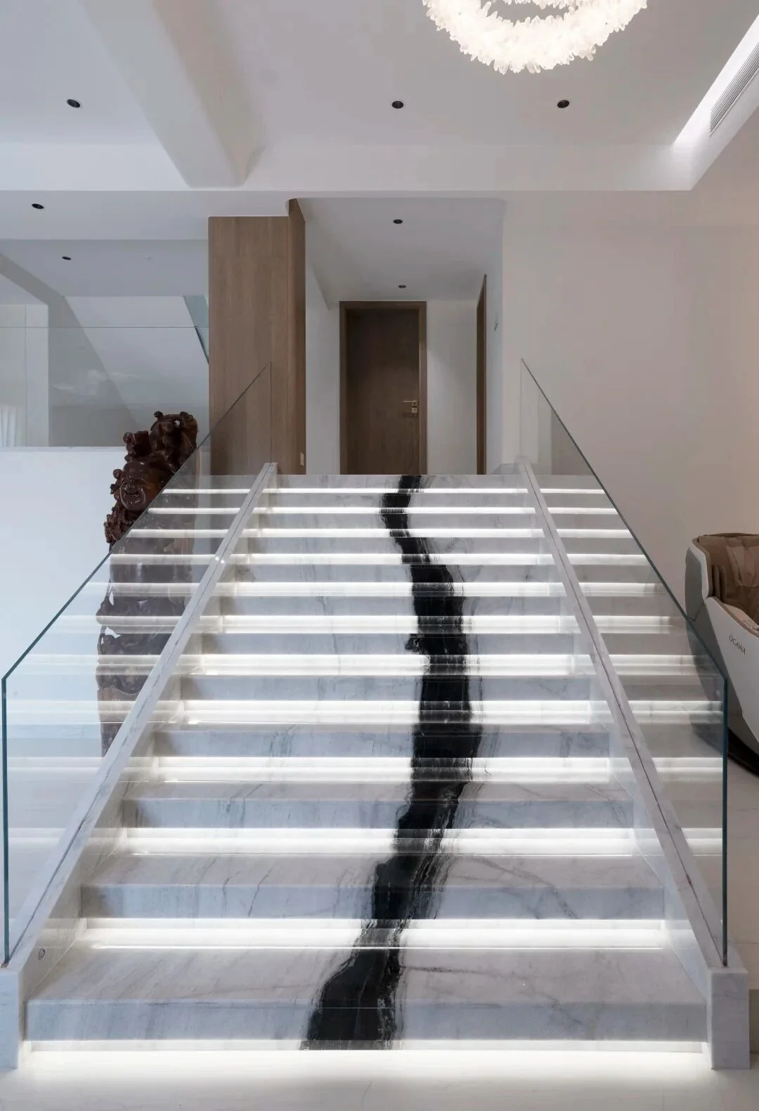 Straight illuminated staircase with a central black Panda White Marble vein