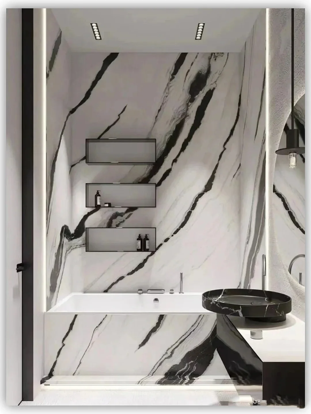 Bathroom clad with large-format Panda White Marble panels and a black basin