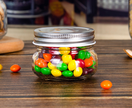 A glass jar contains round colored candies-Glass Candy Jars