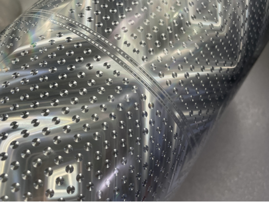 Photographed holographic foil with angle-dependent optical highlights.