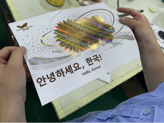 Foil-decorated paper sample showing fine lines and a larger metallic area.