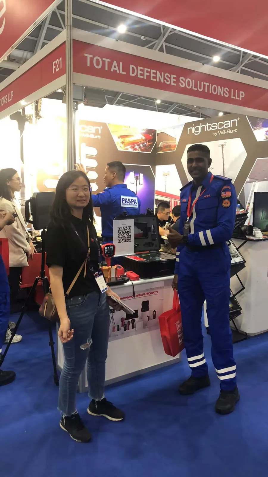 IMG-03 | LSJ Staff with PASPA Officer at Rescue Booth LSJ staff member with an officer in a blue PASPA uniform at the emergency rescue products display during SIDEX 2025 Singapore