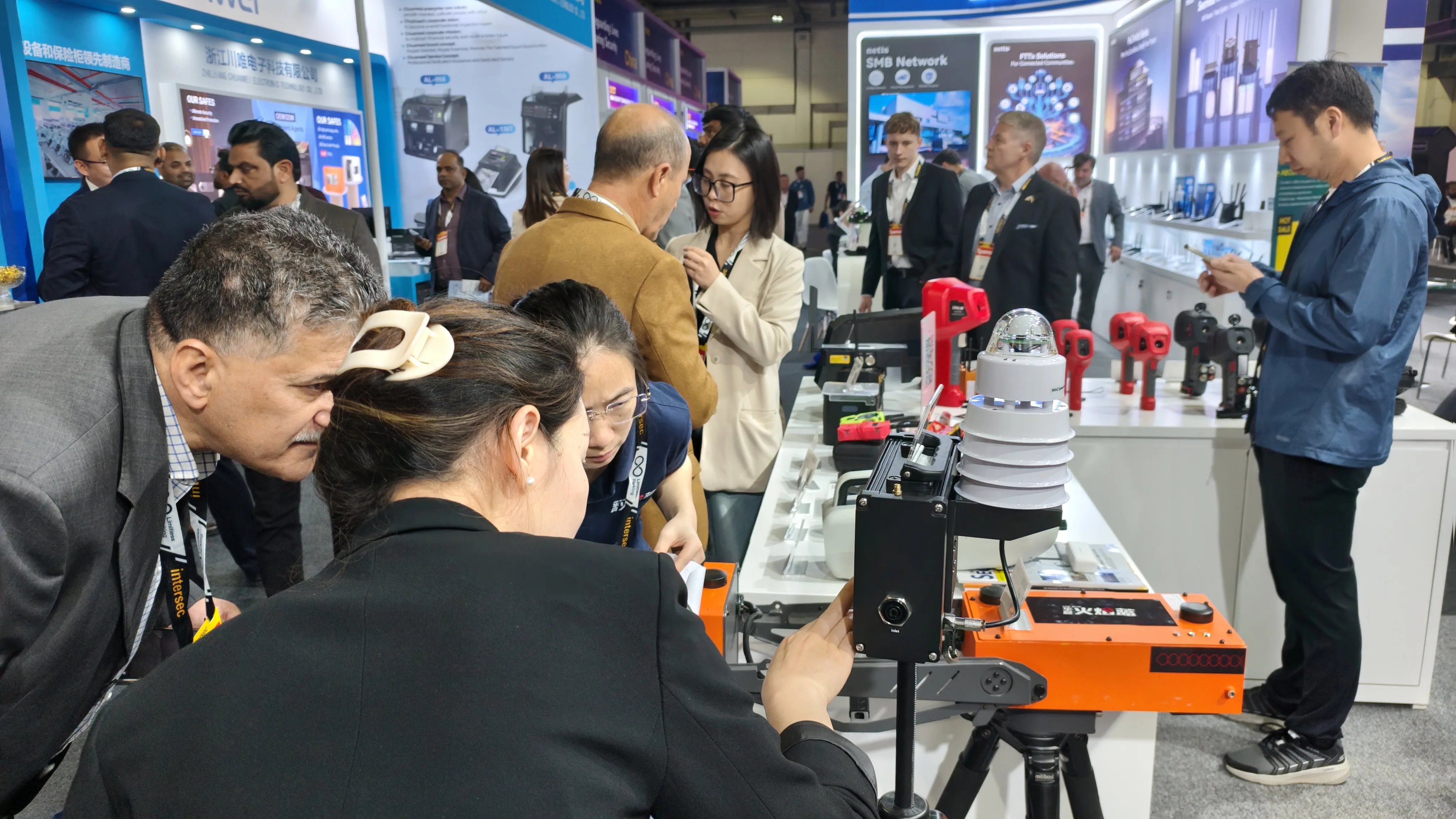IMG-10 | LSJ Booth Visitor Traffic at INTERSEC 2026 Steady visitor traffic at the LSJ booth table as delegates examine red and orange rescue detection equipment during INTERSEC 2026 in Dubai.