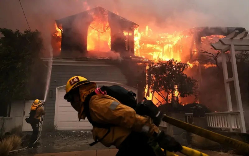 Firefighters battling a fully engulfed residential structure during the 2025 Southern California wildfires in Los Angeles