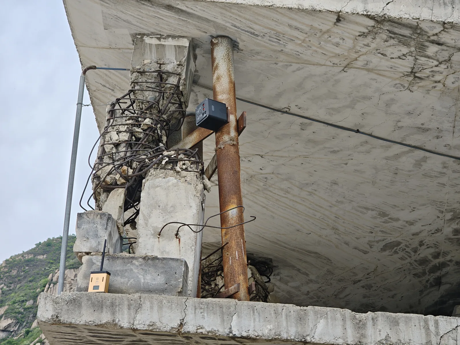 LSJ LS-D01 node and linked wireless alarm unit monitoring a collapsed reinforced concrete structure with exposed rebar