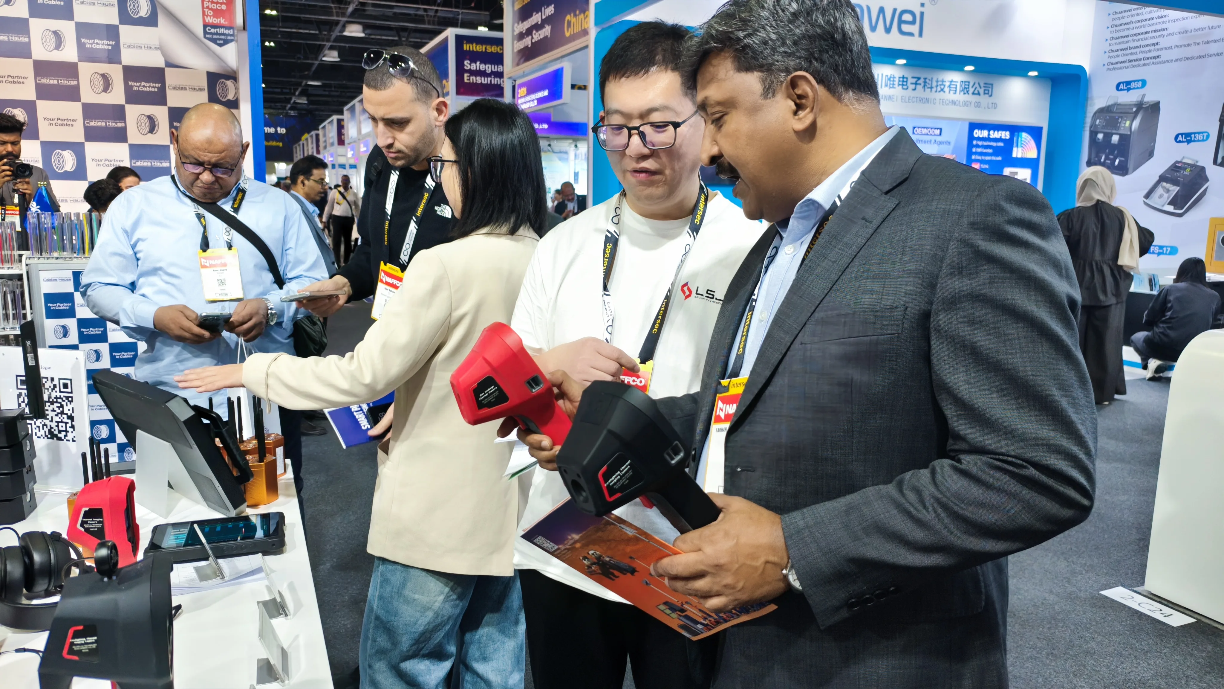 IMG-07 | LSJ Handheld Detector MENA Briefing LSJ product specialist briefing a Middle East and North Africa delegation on a red handheld detection device at the INTERSEC 2026 booth.