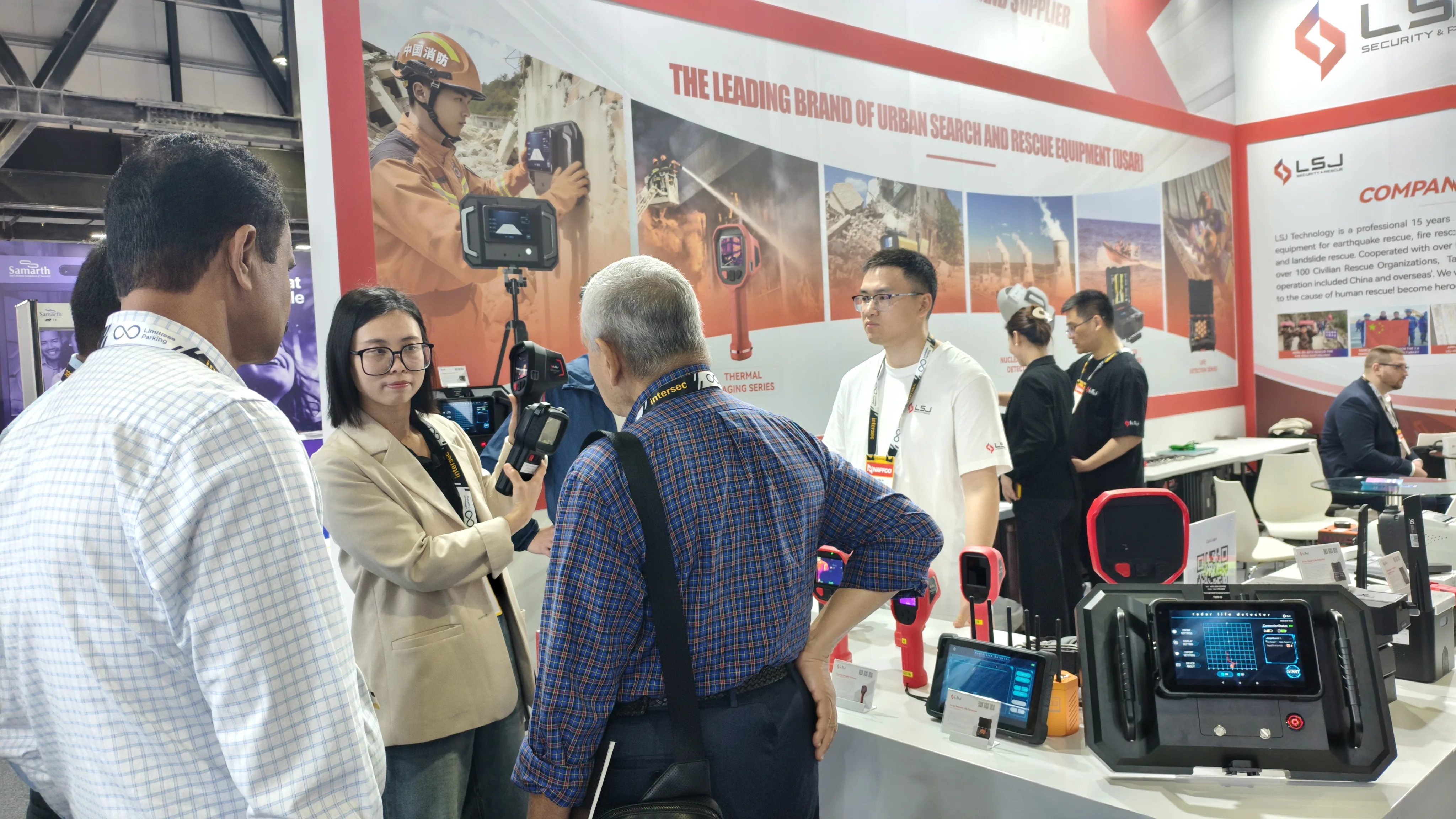 IMG-03 | LSJ USAR Equipment Lineup Demo LSJ product specialist walking a regional buyer through the urban search and rescue (USAR) equipment lineup on the booth wall at INTERSEC 2026 Dubai.