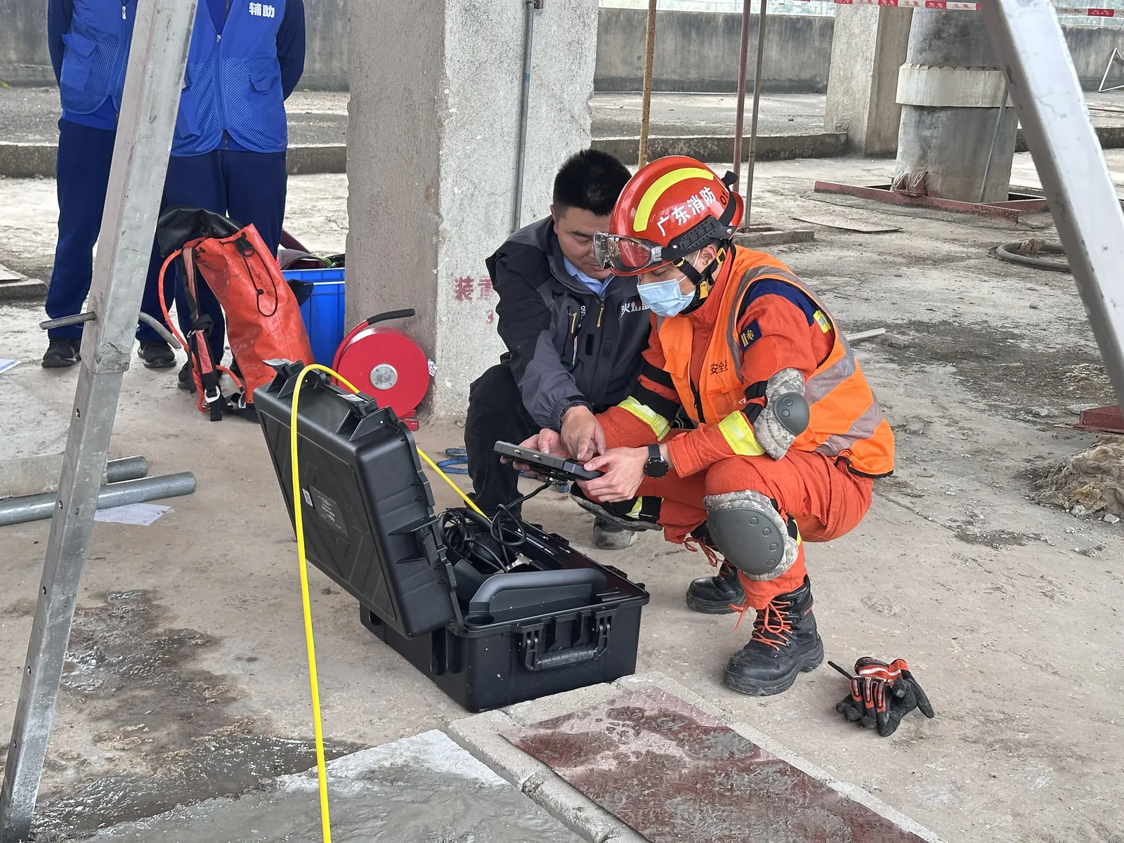 Rescue technician and firefighter reviewing live CAMB-V500 probe video on site