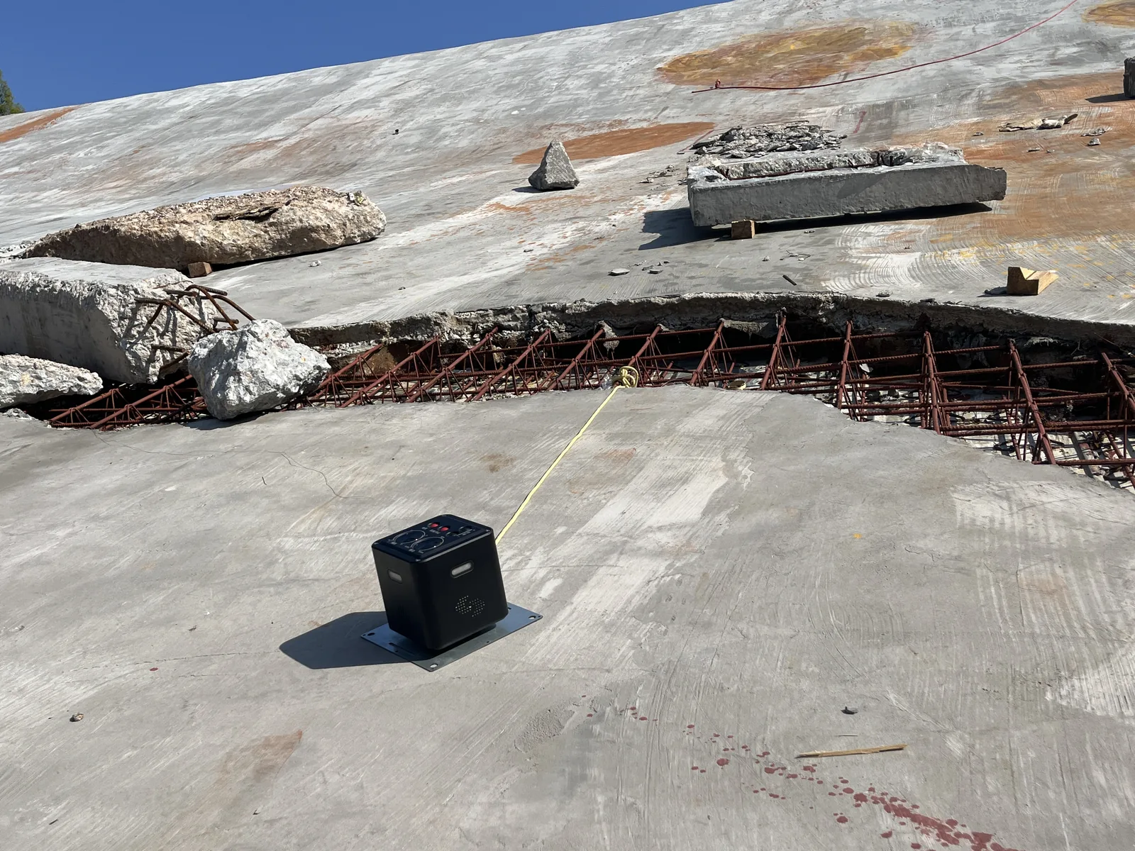 LSJ LS-D01 on a steel base plate tethered with rope to a cracked tilted concrete slab for slope and debris monitoring