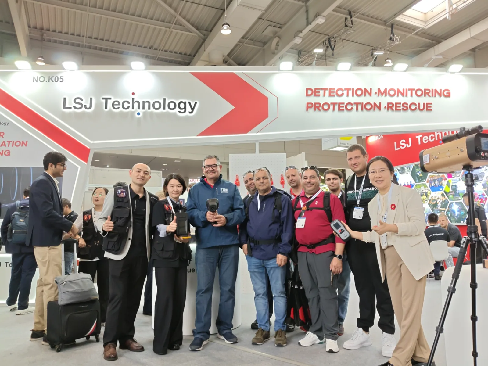 IMG-09 | International Rescue Delegation Group Photo Large international delegation of rescue professionals joining the LSJ team for a group photo under the LSJ Technology booth NO.K05 sign at the Hannover Fire and Rescue Exhibition 2026