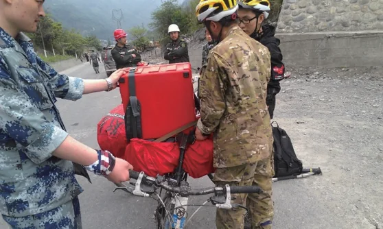 Search-and-rescue personnel transporting rescue equipment on foot during the Ya an earthquake response