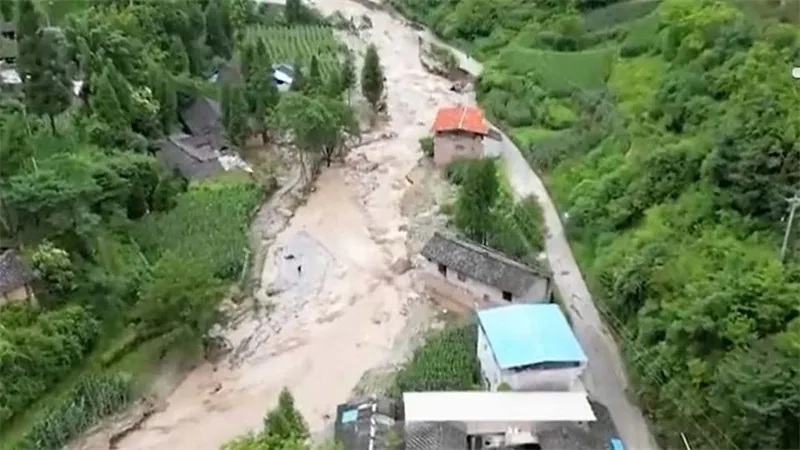 Aerial view of a mudslide path cutting through a mountain village after a flash flood