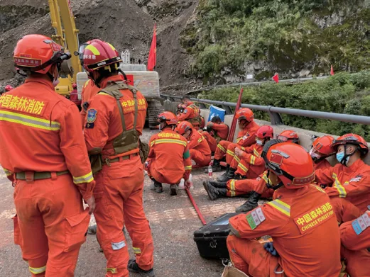 Fire rescue crews operating at a landslide-blocked mountain road during the Luding earthquake response