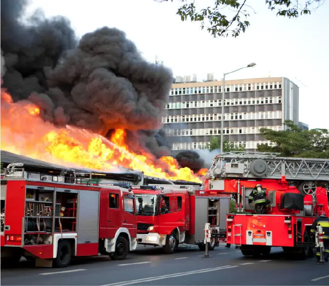 Fire engines responding to a burning building, a firefighting scenario where thermal imaging cameras locate hotspots and trapped people through smoke
