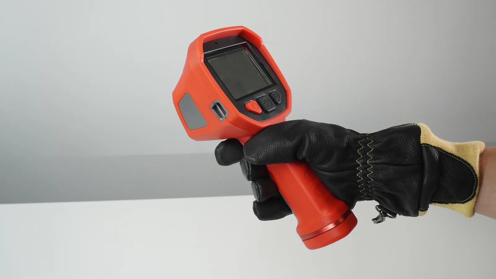 Firefighter wearing a structural rescue glove operating the LSJ TIG10 gas detection camera one handed with full grip control
