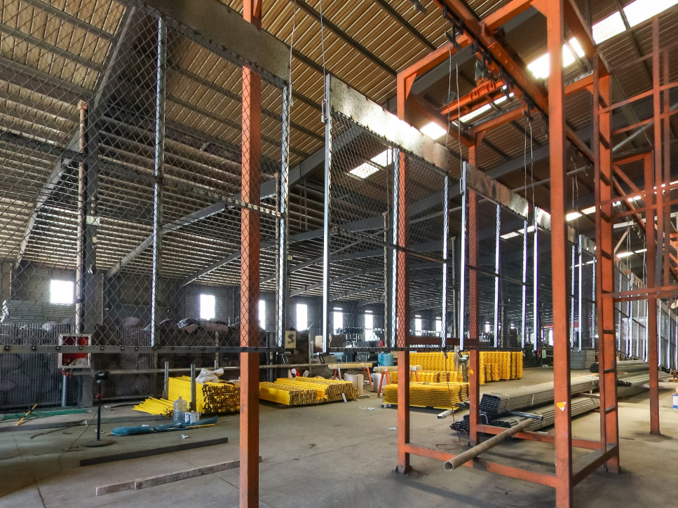 Spray painting workshop - Orange conveyor rack and yellow fence panel