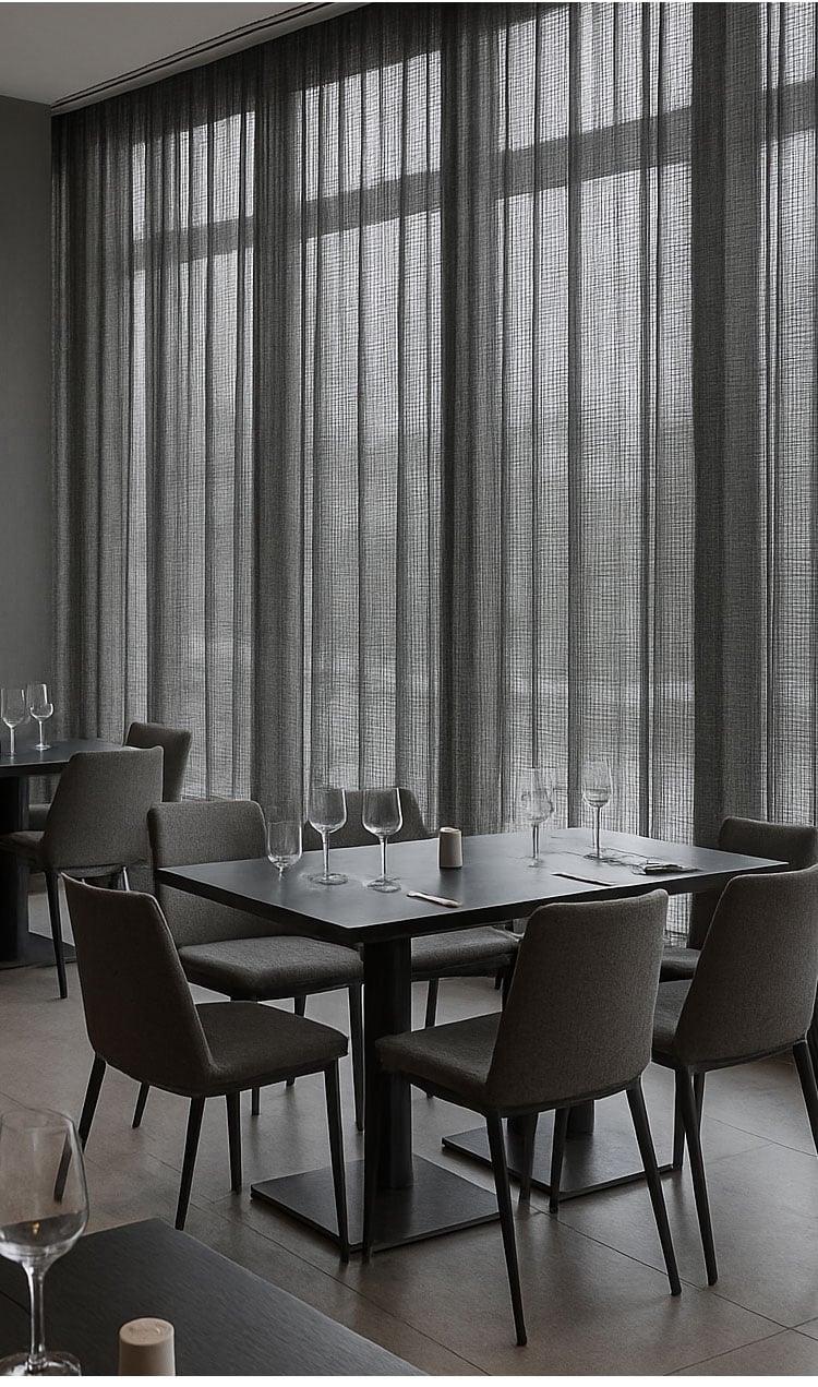 Close-up interior scene behind sheer curtains with soft filtered light, highlighting texture and privacy balance.