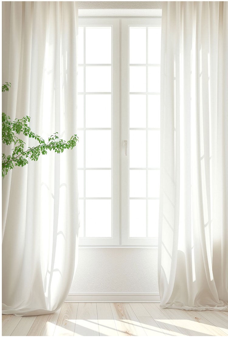 Sheer white curtains on a tall window, gently filtering sunlight to keep the space bright while maintaining privacy.