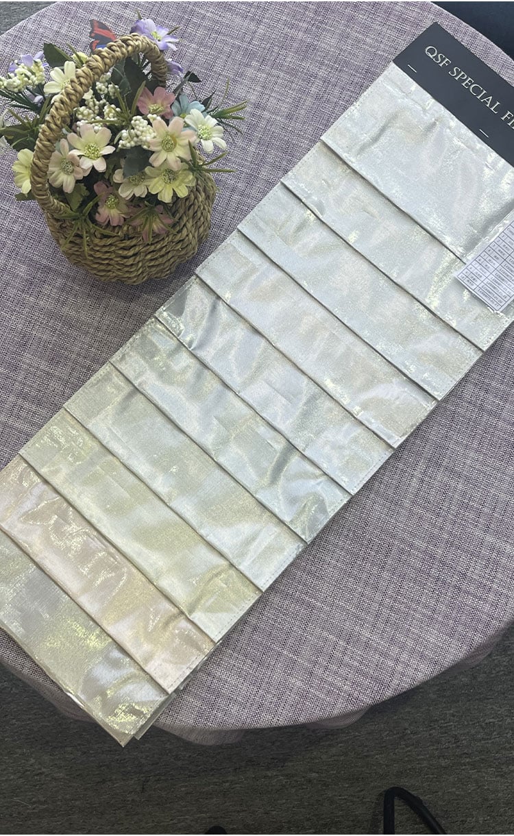 Lurex glitter fabric sample swatches displayed on a sample card, showing subtle metallic shine and color options.