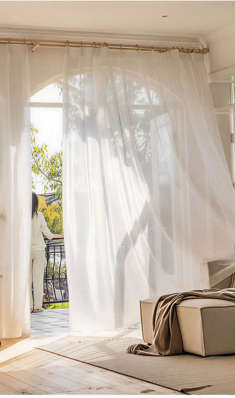 Breezy white sheer curtains by a balcony door, translucent flow and elegant drape of terylene voile
