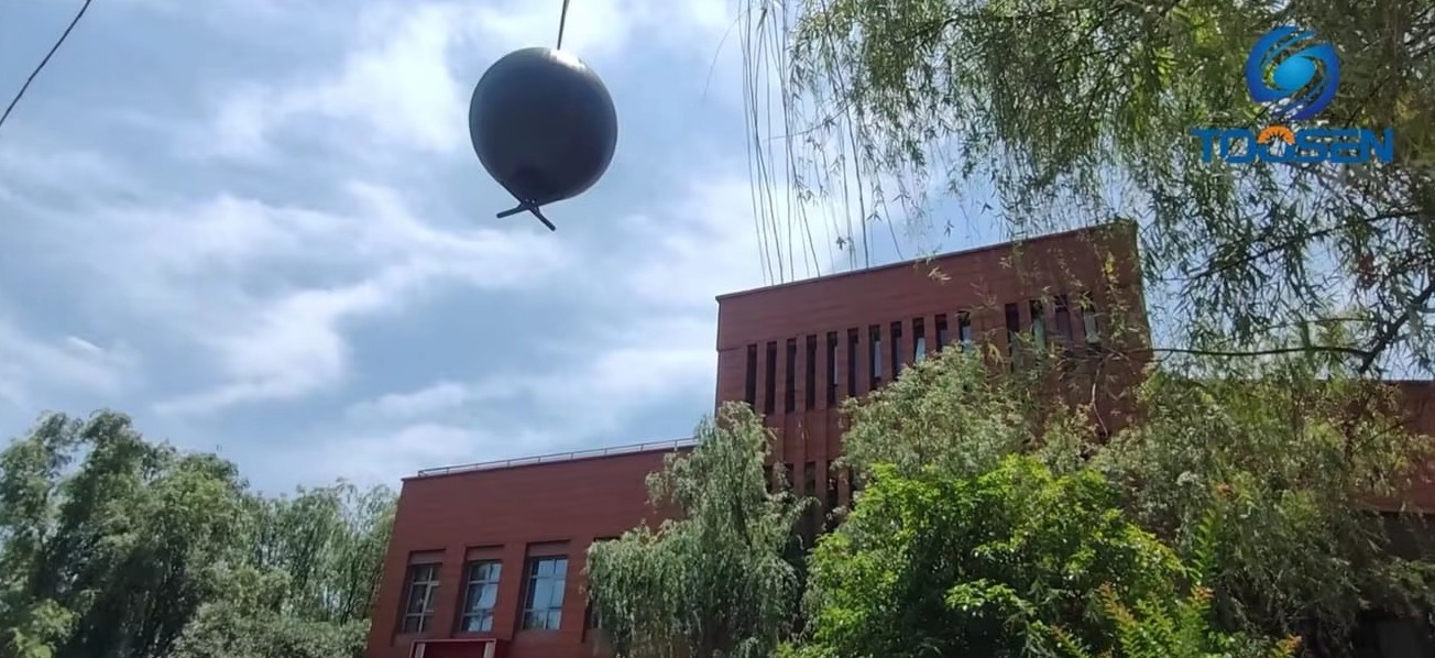 TOOSEN LED sphere being lifted by crane during rooftop installation