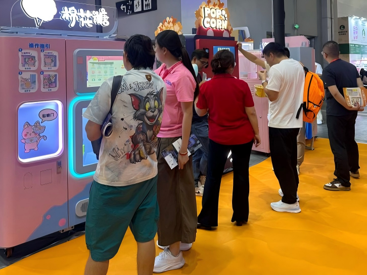 Buyers observing the production process of the automatic cotton candy vending machine MG330Pro.png
