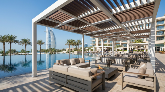 This rooftop lounge in Dubai Marina utilizes a charcoal-grey WPC pergola system to provide shade while maintaining a contemporary, high-end aesthetic that resists the corrosive salt air of the Arabian Gulf.